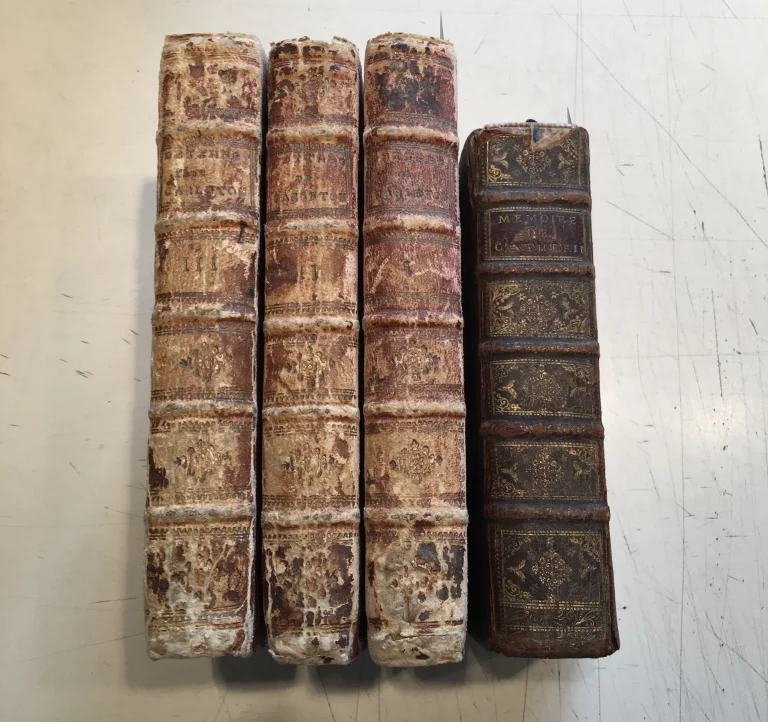 Quatre livres anciens à la reliure en cuir très abîmée, avant restauration à l’Atelier de Reliure Paris. Traces d’usure, cuir craquelé, dos endommagés