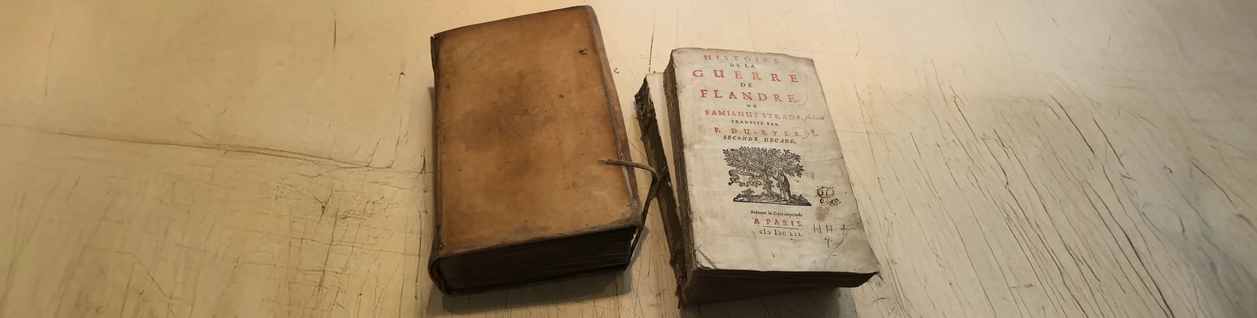 Livre ancien endommagé “Histoire de la guerre de Flandre” prêt à être restauré, photographie illustrant l’expertise en restauration patrimoniale de l’atelier de reliure dorure à Paris