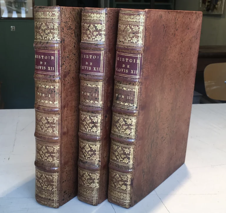 Trois volumes restaurés de “L’Histoire de Louis XII”, reliés en cuir marbré avec dorure à chaud, après restauration complète à l’Atelier de Reliure Paris, dirigé par Greg, relieur-doreur installé Place Dauphine