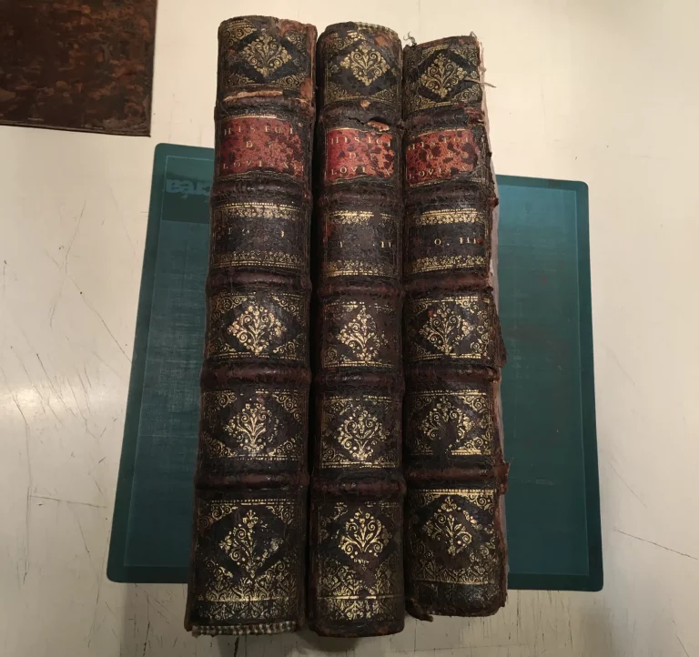 Trois volumes anciens Histoire de Louis XII en cuir abîmé et usé, avant restauration artisanale à l’Atelier Reliure Paris